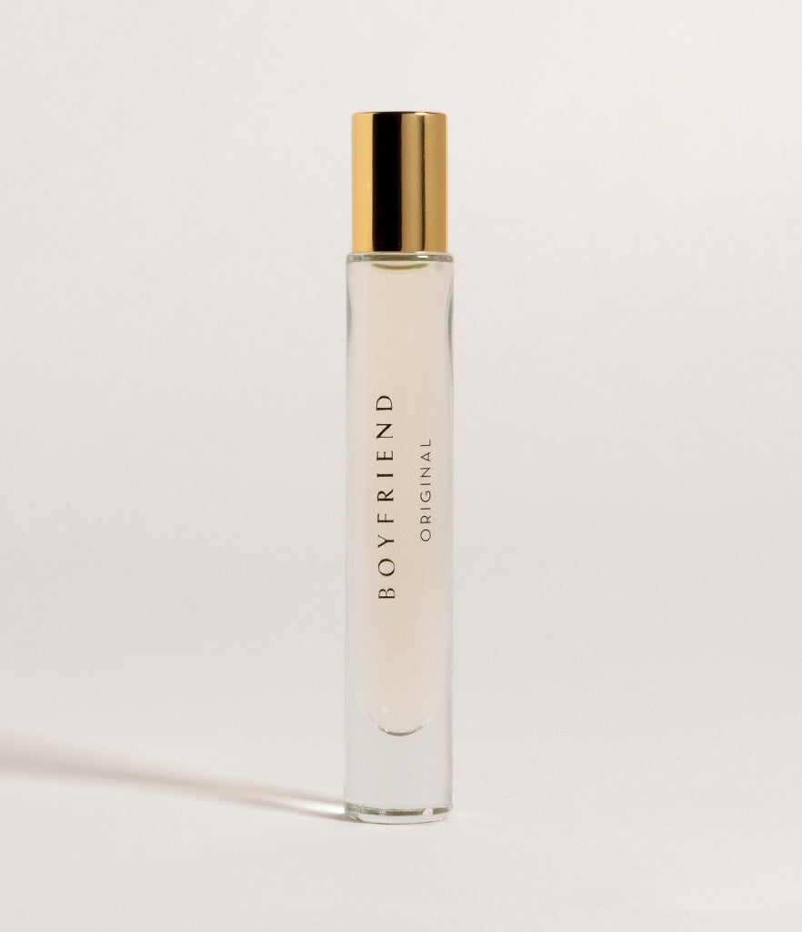 A rollerball perfume with a clear body and gold-colored cap, labeled 'BOYFRIEND', against a white background.