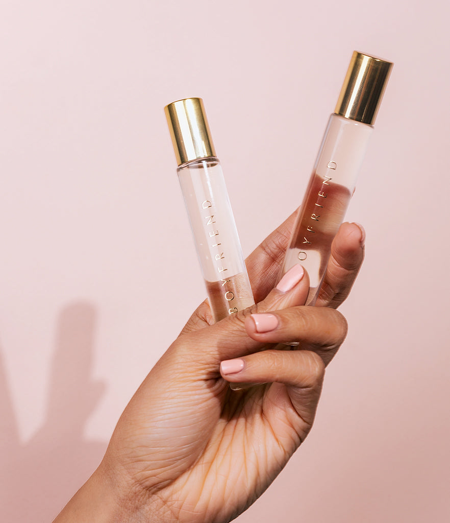 Manicured hand holding two Boyfriend Rollerballs.