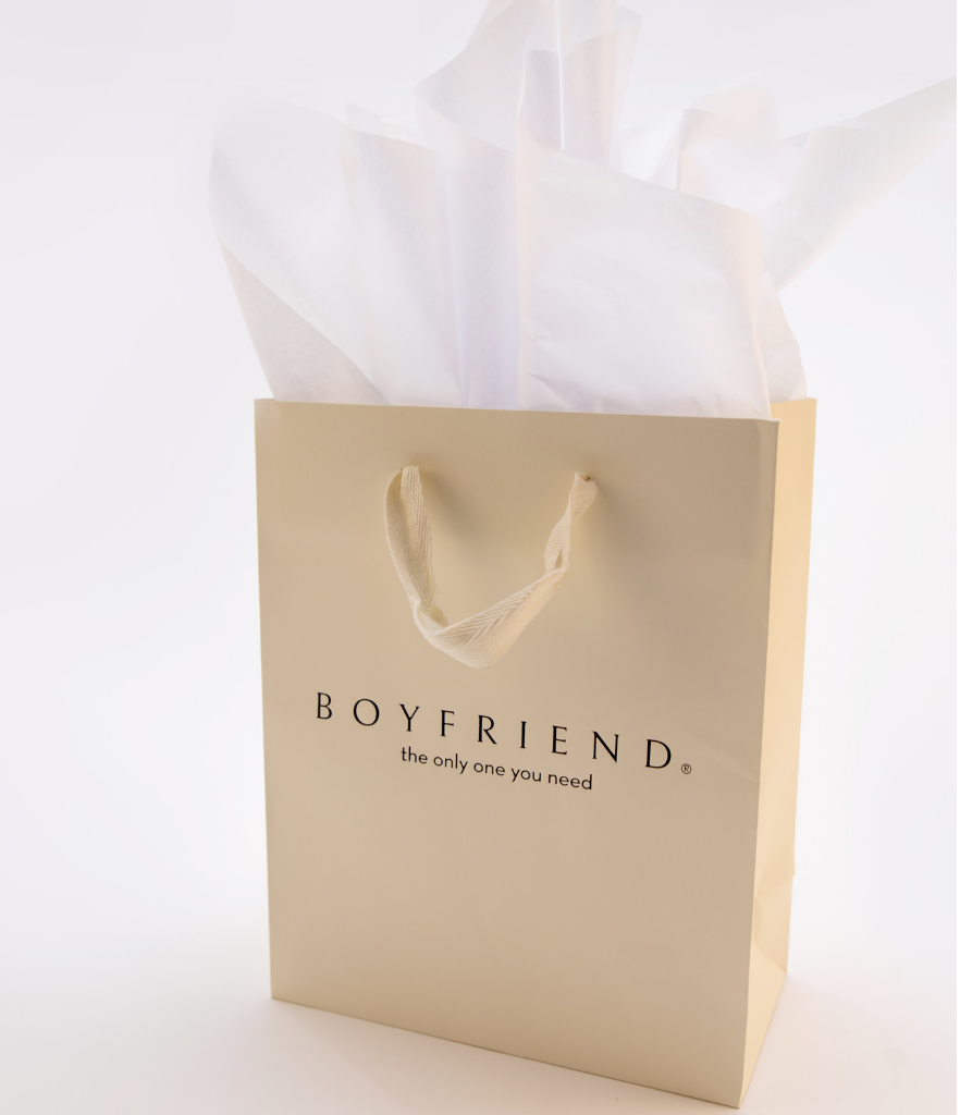 Single cream bag with fabric handles and boyfriend in black printed on one side with white tissue paper